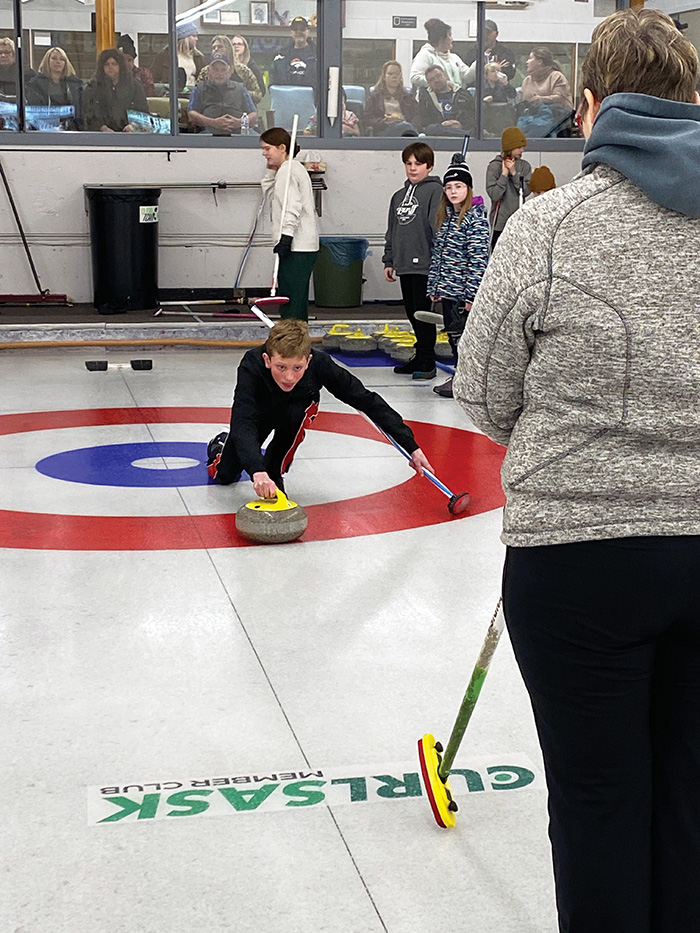 Barb Swallow checking on a proper curling delivery.”></a><br />
<p class=